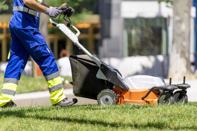 Garden worker mowing the lawn