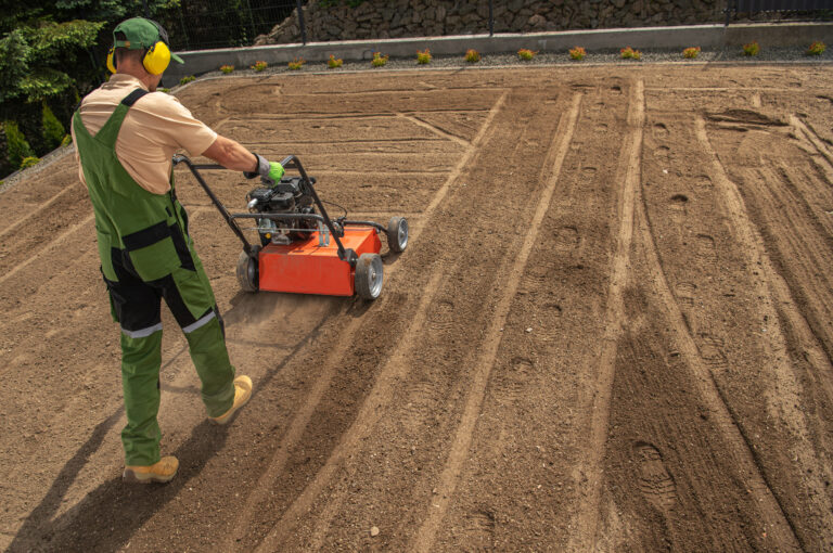 Landscaping Worker Preparing Backyard Garden Soil Using Aerator