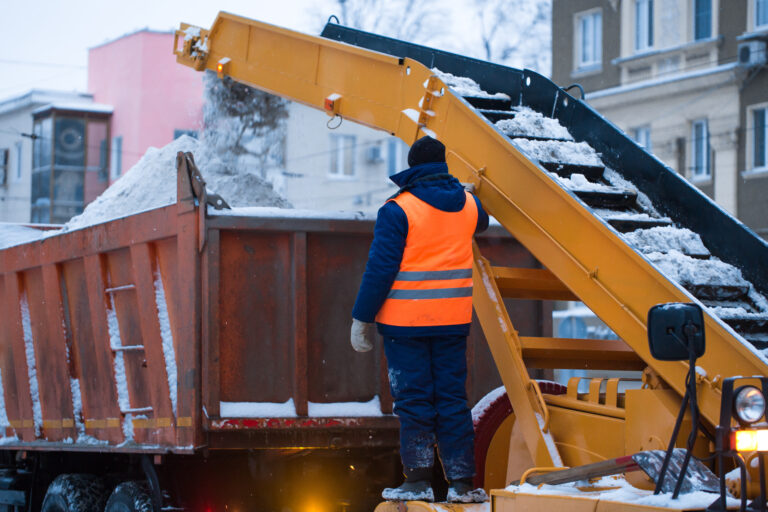 Snow cleaning tractor snow-removal machine loading pile of snow on a dump truck. Isolate. Snow plow