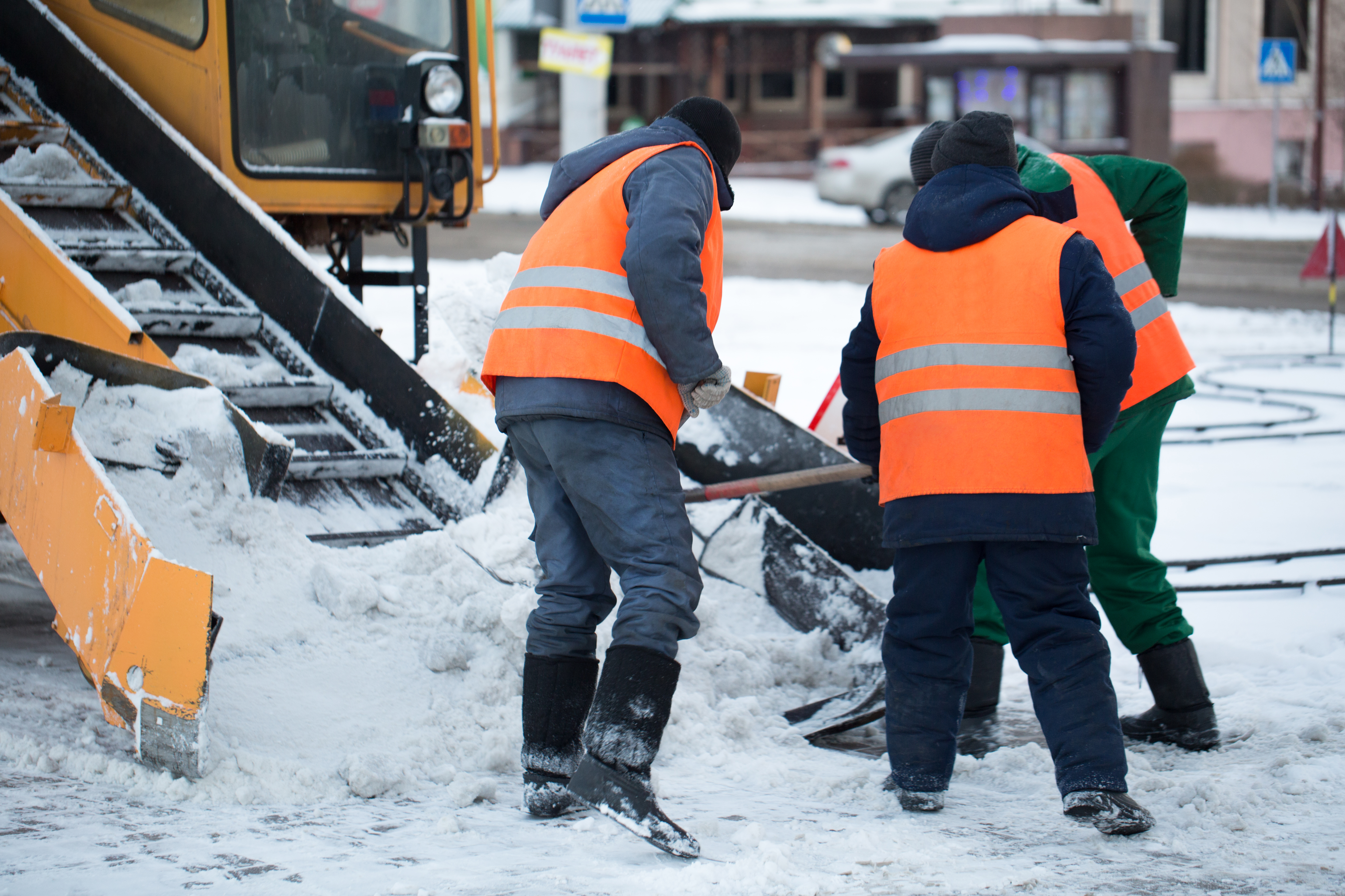 Tractor cleaning the road from the snow. Excavator cleans the streets of large amounts of snow in