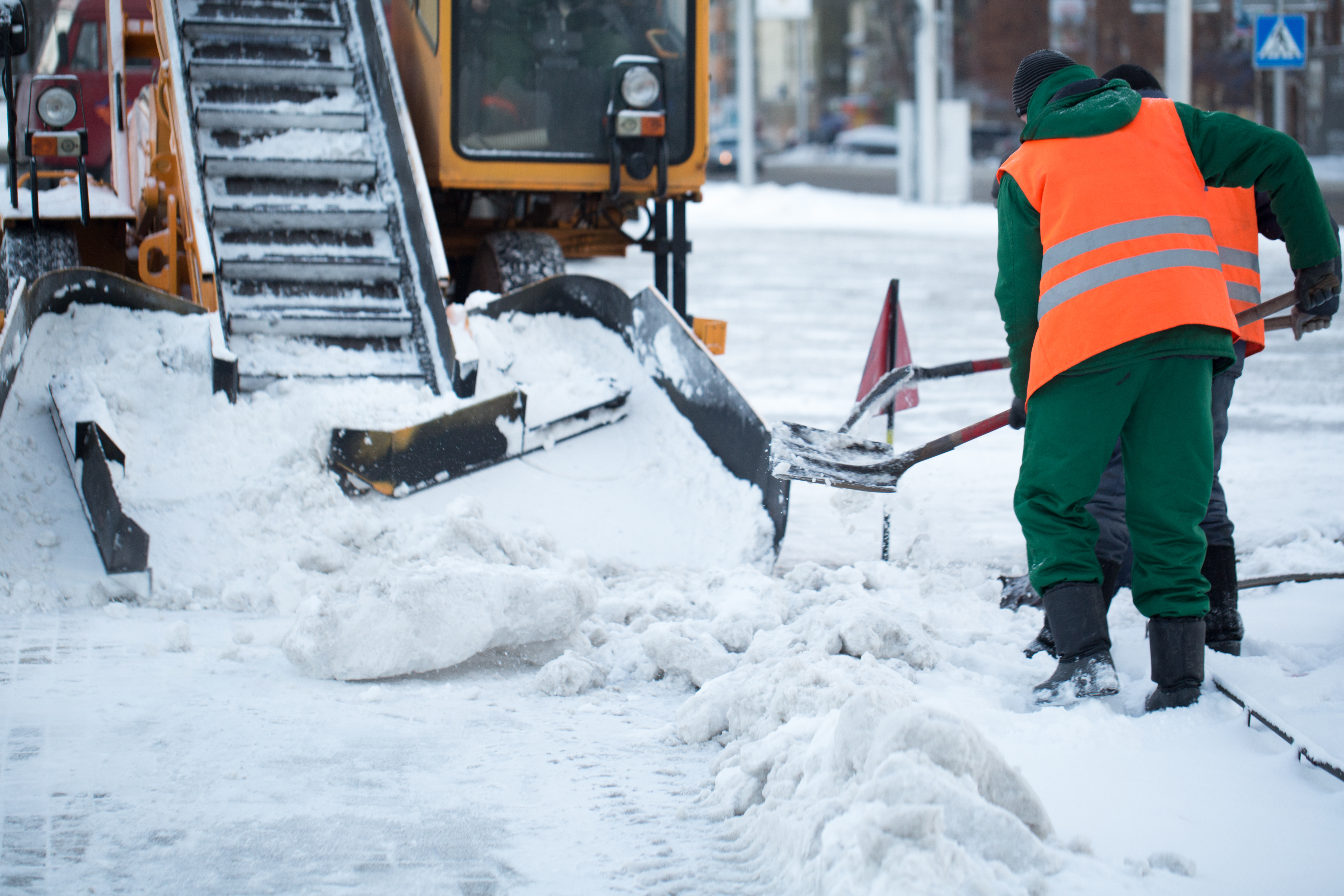 Tractor cleaning the road from the snow. Excavator cleans the streets of large amounts of snow in