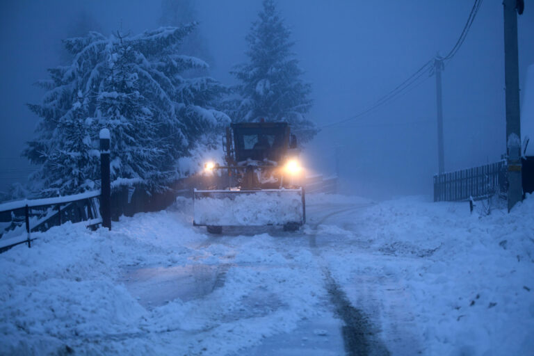 Truck cleaning road in winter